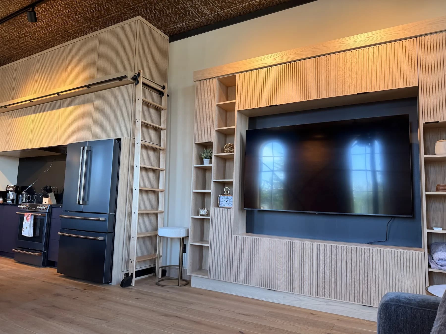 Living area with built-in media wall and kitchen beyond